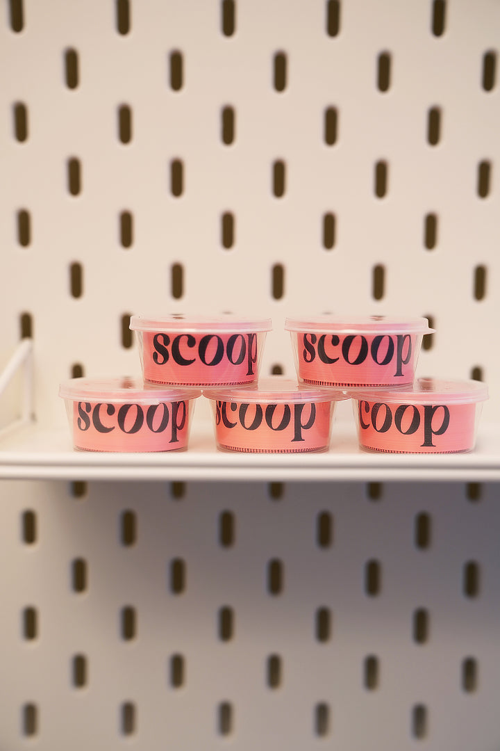 Scoop measuring tapes stacked on a shelf, ready for an at-home measurement